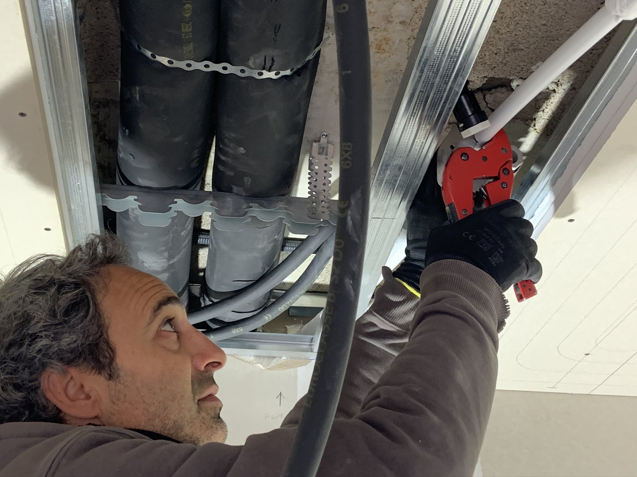 Fotografía de un trabajador de Serintalt realizando la instalación de superficies radiantes.
