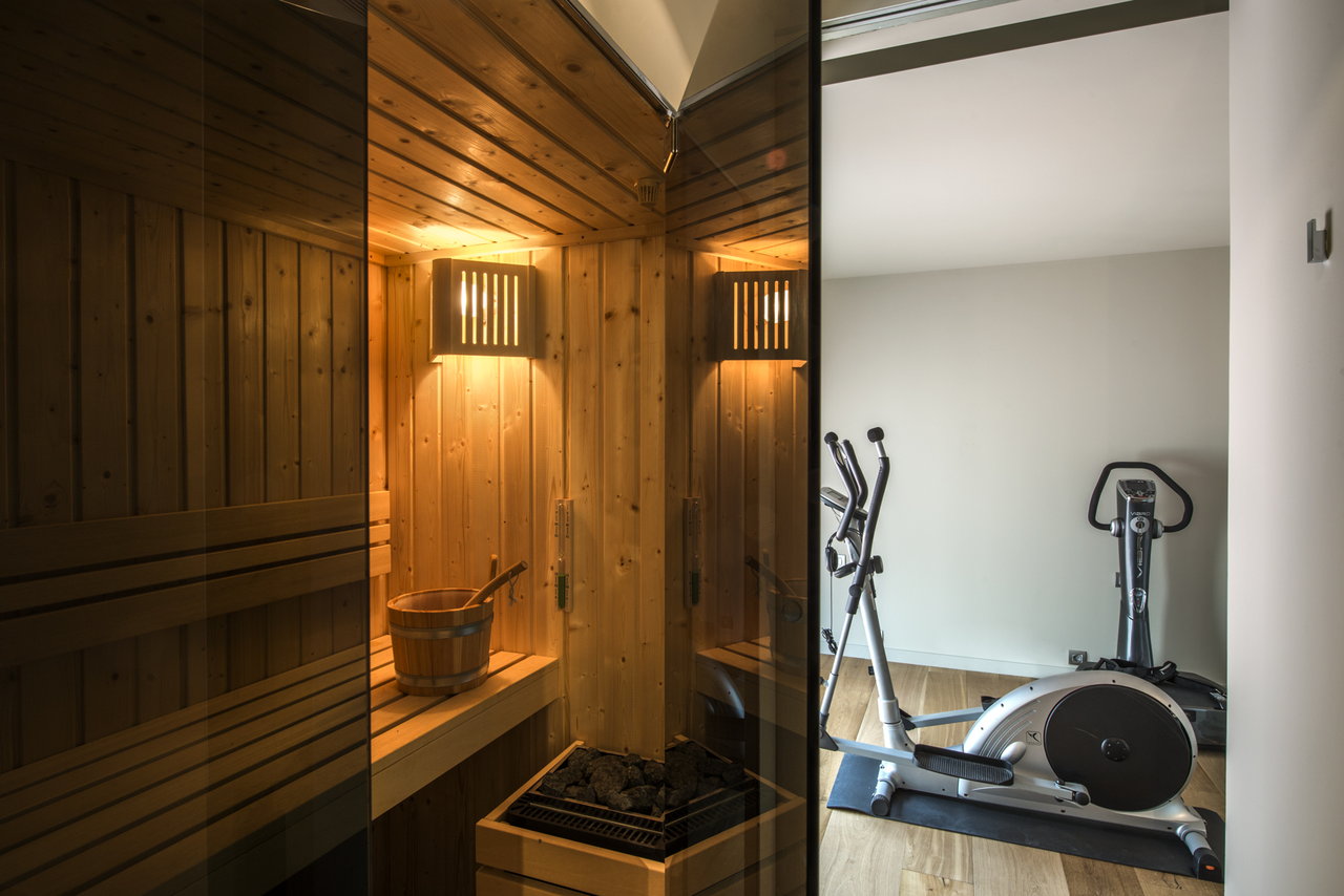 Se puede observar una sauna y máquinas de gimnasio en una casa.